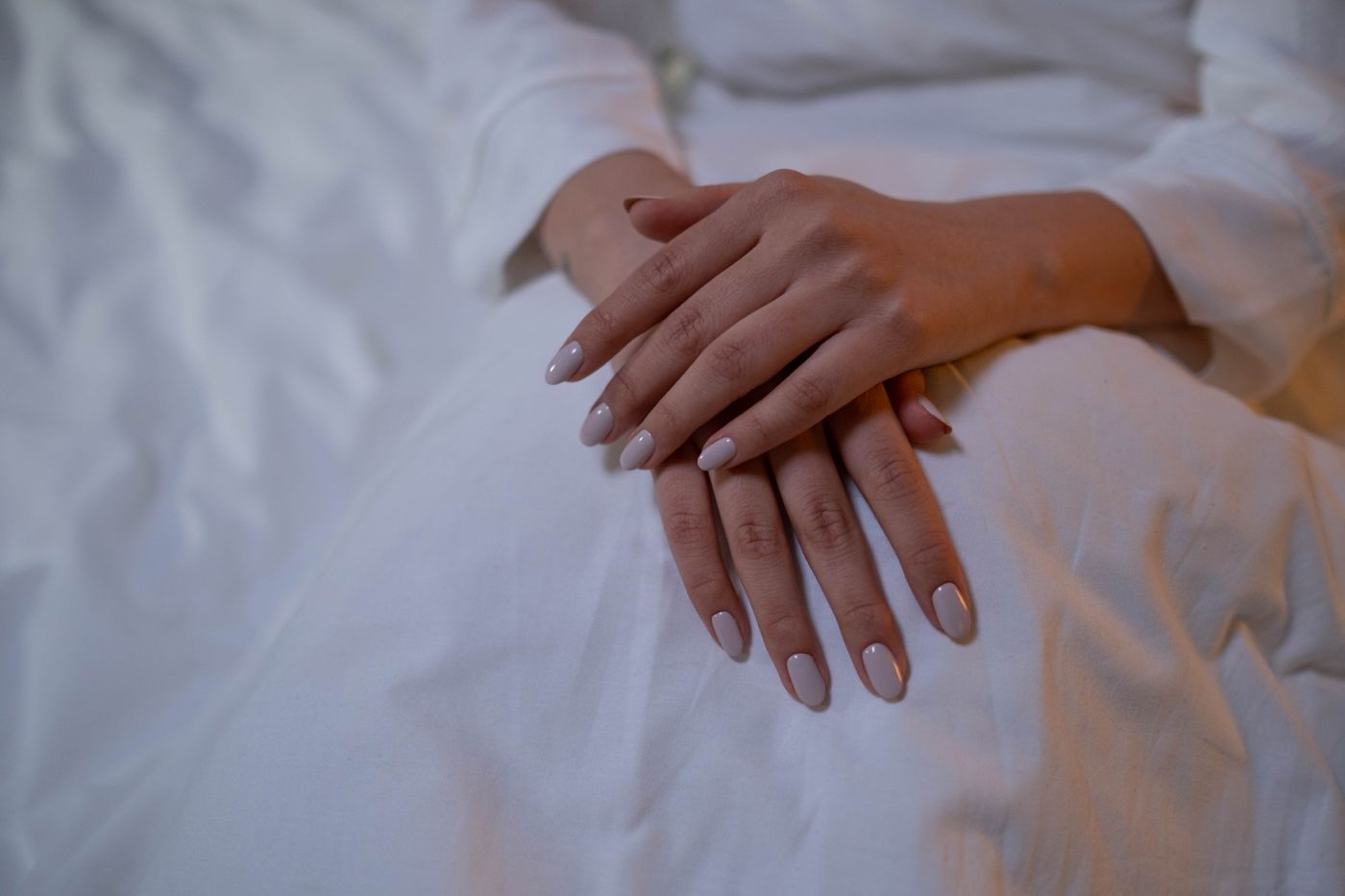 Neutral almond-shaped manicure on softly posed hands